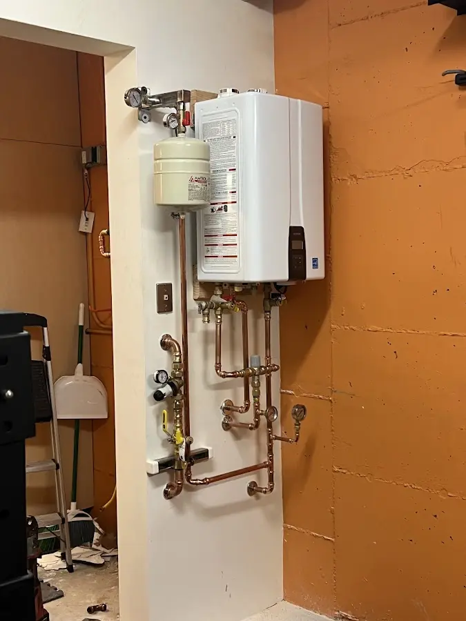 Plumbing technician inspecting water heater connections in Bucksport